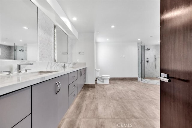 bathroom featuring toilet, vanity, and tiled shower