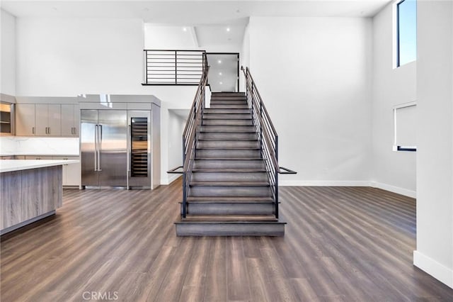 stairs with a high ceiling and hardwood / wood-style floors