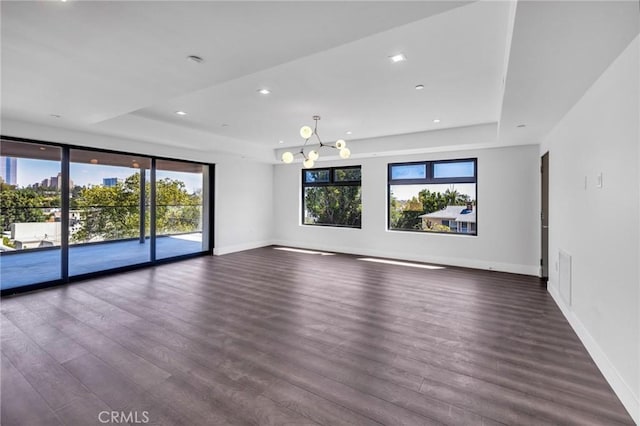 interior space featuring dark wood-type flooring and a tray ceiling