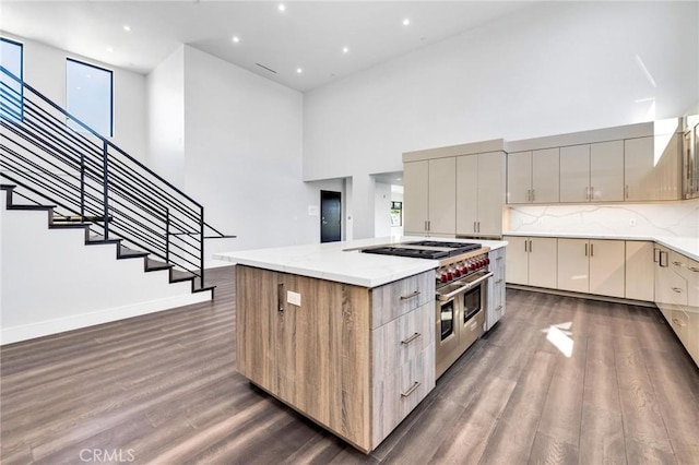 kitchen featuring a high ceiling, dark hardwood / wood-style flooring, tasteful backsplash, and a kitchen island