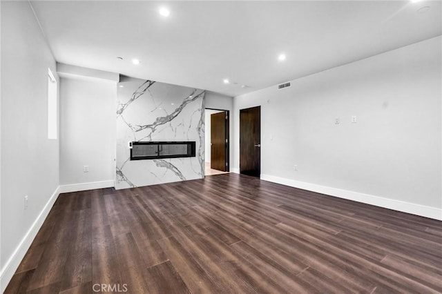 unfurnished living room featuring wood-type flooring and a high end fireplace