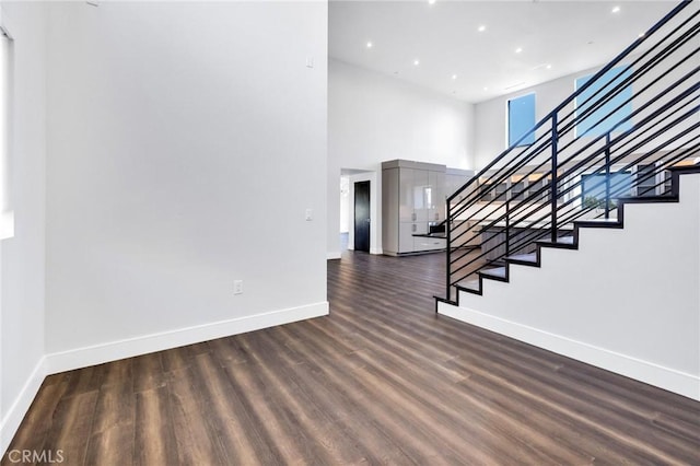 interior space with a high ceiling and wood-type flooring