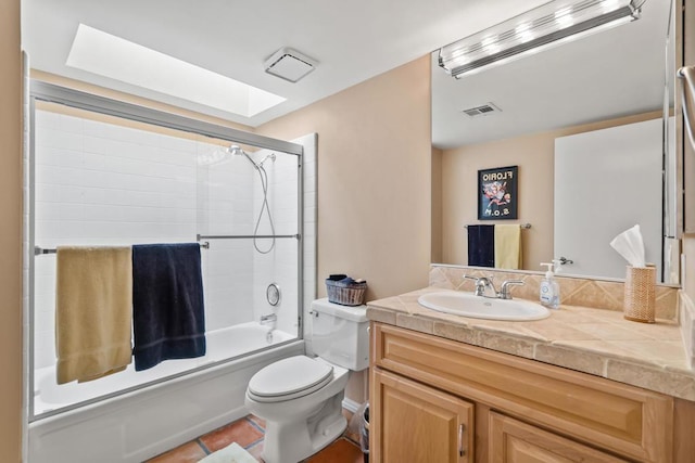 full bathroom featuring toilet, bath / shower combo with glass door, vanity, tile patterned floors, and a skylight