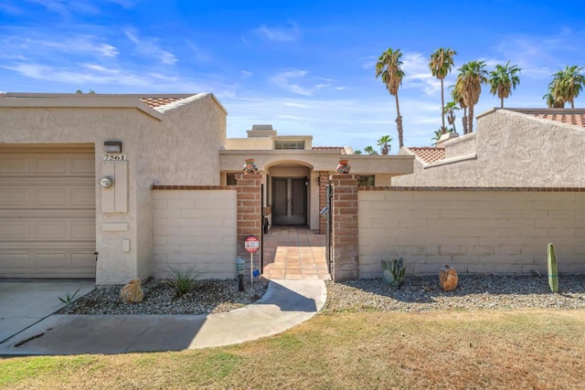 pueblo-style house featuring a garage