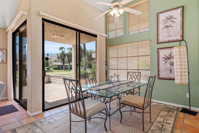 tiled dining area with ceiling fan and lofted ceiling