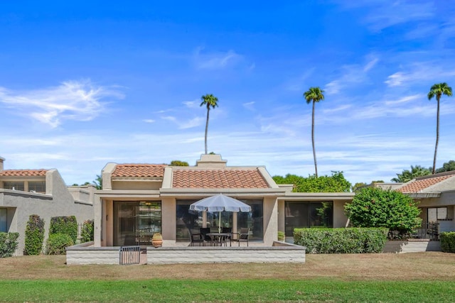 back of property featuring a patio area and a yard