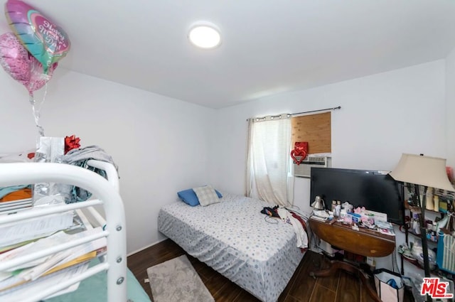 bedroom with dark hardwood / wood-style flooring