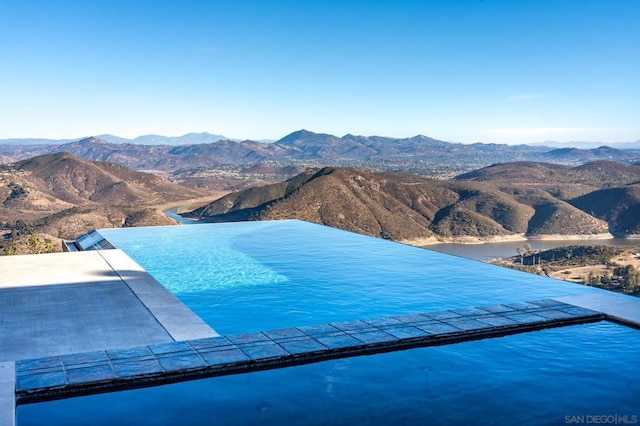 view of swimming pool with a mountain view