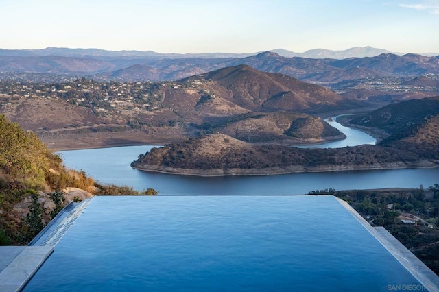 drone / aerial view featuring a water and mountain view