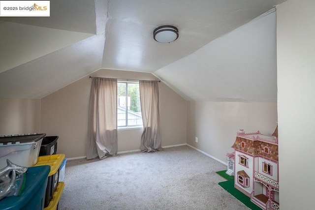 additional living space with vaulted ceiling and carpet