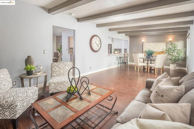 living room featuring beam ceiling and dark hardwood / wood-style floors