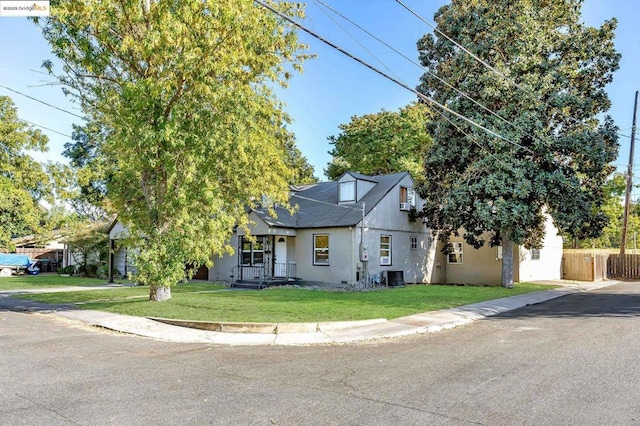 view of front of property with central AC and a front yard