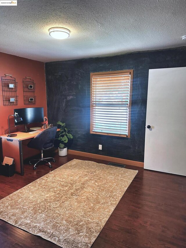 office space featuring dark wood-type flooring and a textured ceiling