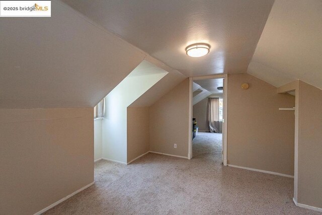 bonus room featuring light colored carpet and lofted ceiling