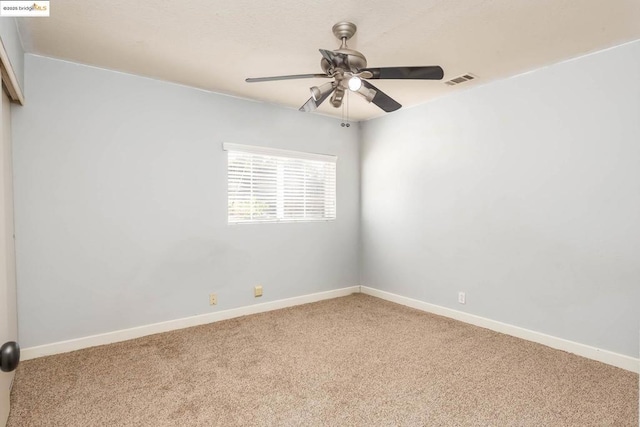 carpeted spare room featuring ceiling fan