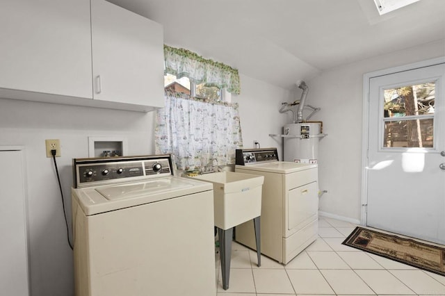 laundry area featuring cabinets, separate washer and dryer, light tile patterned floors, and a skylight