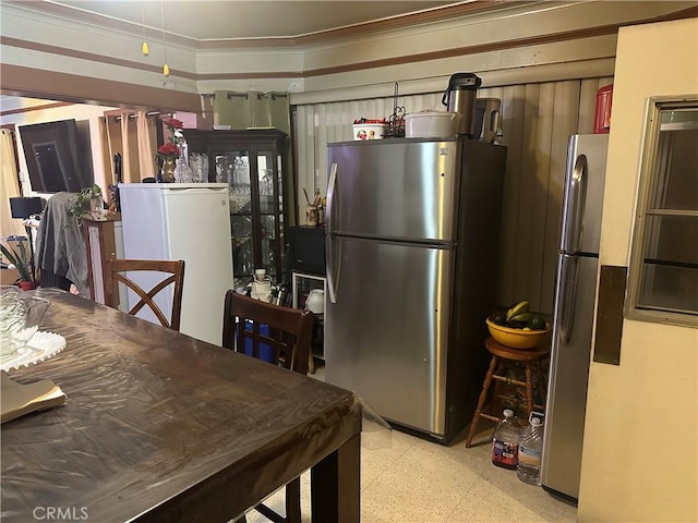 kitchen with crown molding, refrigerator, and stainless steel fridge