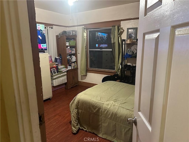 bedroom with dark hardwood / wood-style floors