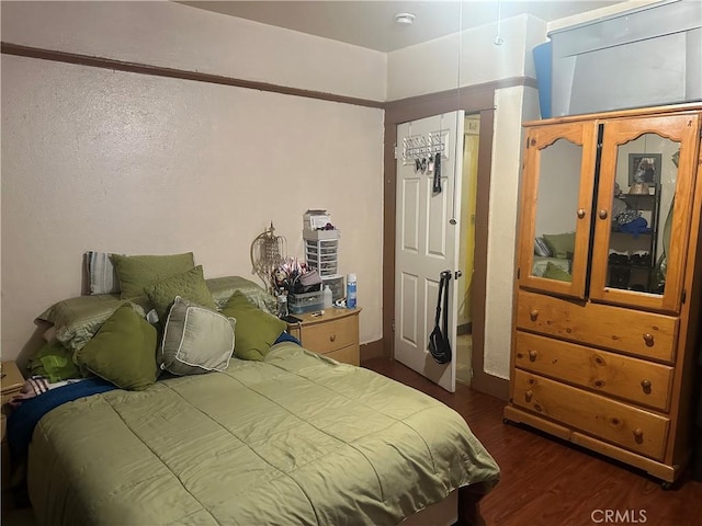 bedroom with dark hardwood / wood-style flooring