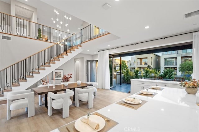 dining space featuring light hardwood / wood-style floors and a notable chandelier