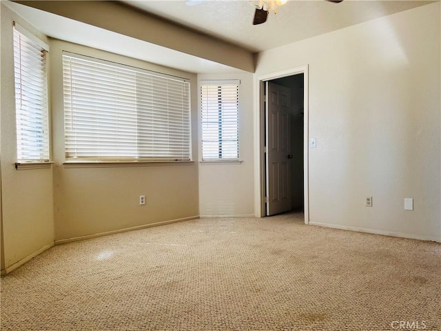 carpeted spare room featuring ceiling fan