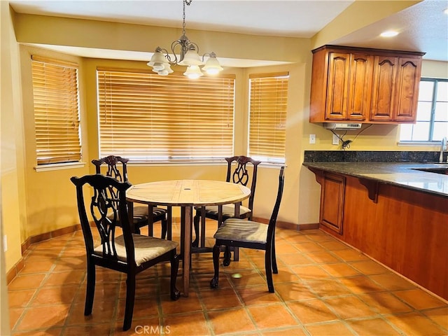 dining room featuring sink, a notable chandelier, and light tile patterned flooring