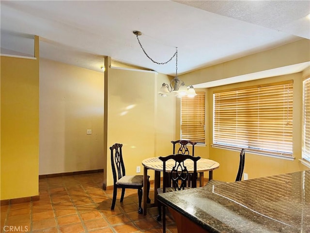 tiled dining area featuring a chandelier