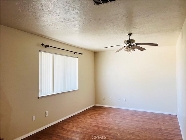 spare room with ceiling fan, a textured ceiling, and hardwood / wood-style flooring