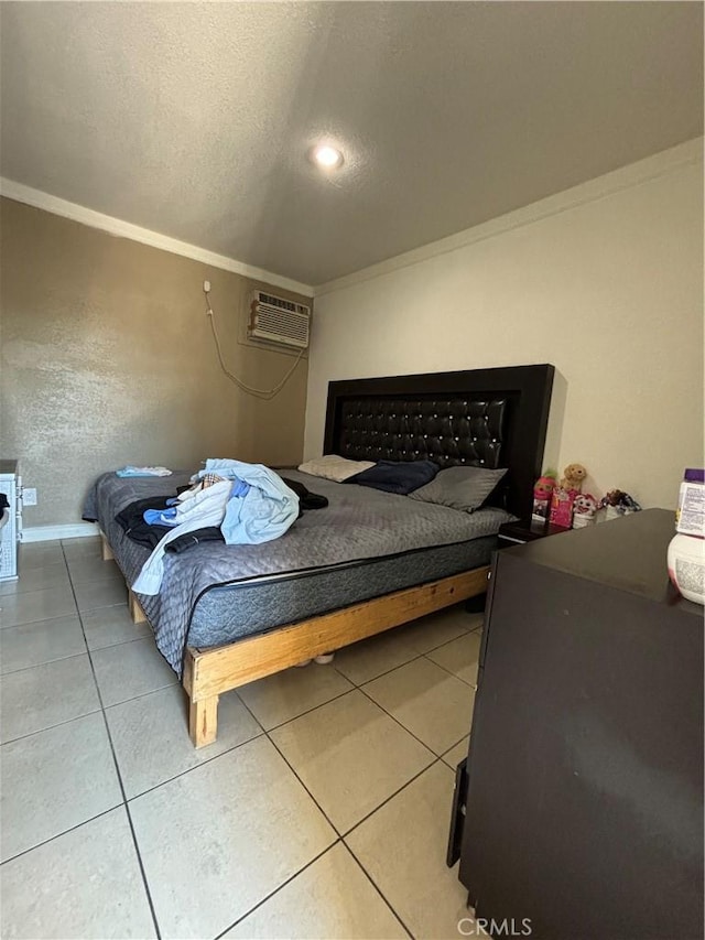 bedroom with a textured ceiling, crown molding, a wall mounted AC, and tile patterned floors