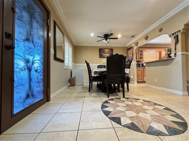 dining area with ceiling fan, ornamental molding, and light tile patterned flooring