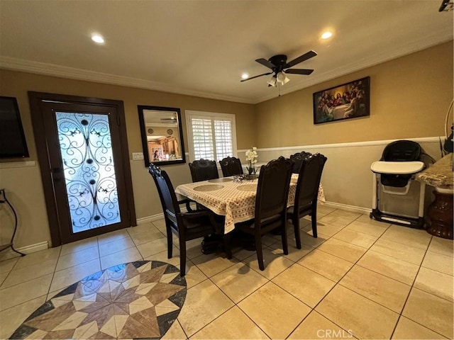 tiled dining area featuring ceiling fan and crown molding