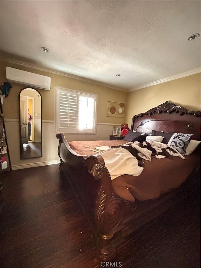 bedroom featuring a wall unit AC, ornamental molding, and dark hardwood / wood-style floors