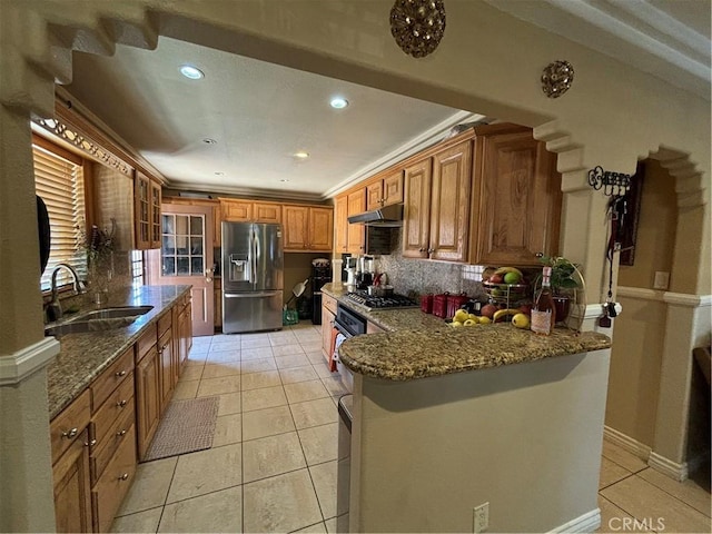 kitchen with light tile patterned flooring, stainless steel appliances, stone counters, and sink