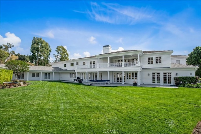 back of property with a patio area, a lawn, and french doors