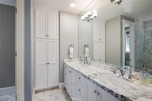 bathroom with toilet, an inviting chandelier, a tile shower, and vanity