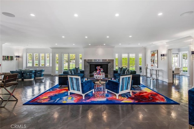 living room featuring a wealth of natural light, dark parquet flooring, and a high end fireplace