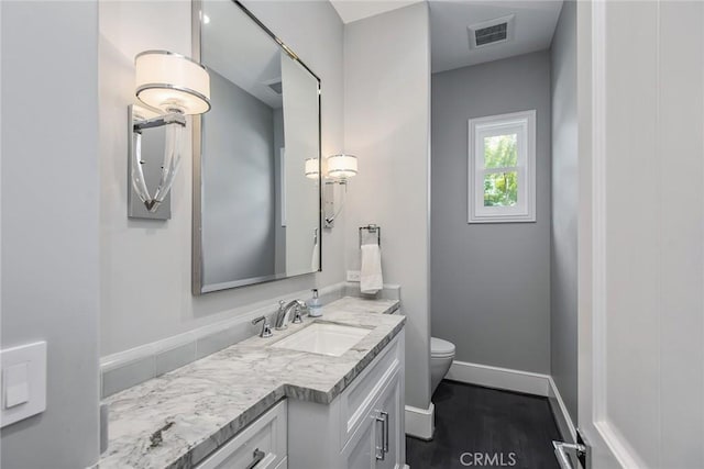 bathroom featuring wood-type flooring, toilet, and vanity