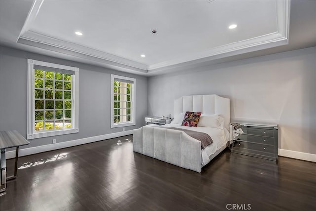 bedroom featuring dark hardwood / wood-style floors, ornamental molding, and a raised ceiling