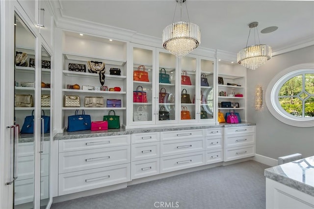 walk in closet featuring light carpet and a chandelier