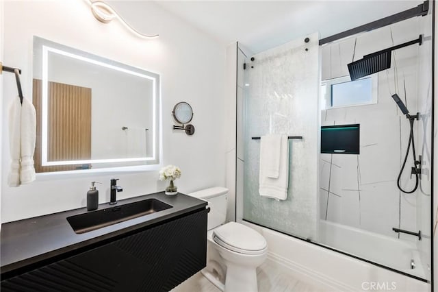 full bathroom featuring toilet, enclosed tub / shower combo, and vanity