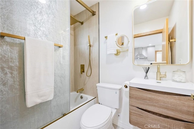 full bathroom featuring toilet, bath / shower combo with glass door, and vanity