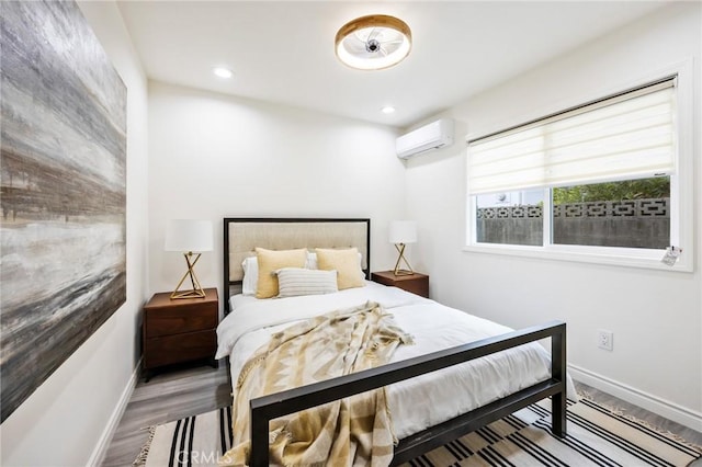 bedroom featuring hardwood / wood-style flooring and a wall mounted air conditioner