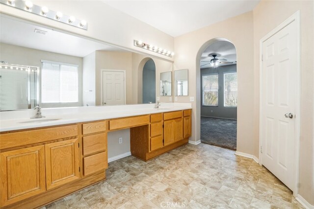 bathroom featuring ceiling fan, a wealth of natural light, vanity, and a shower with door