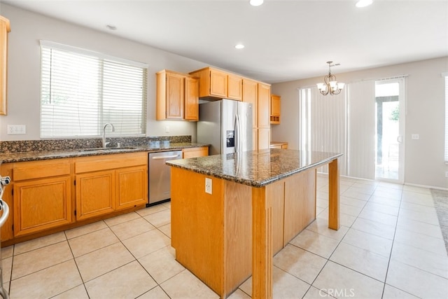 kitchen featuring a kitchen island, stainless steel appliances, sink, hanging light fixtures, and a chandelier