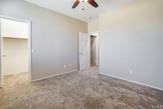 unfurnished bedroom with ceiling fan, light colored carpet, a closet, and a spacious closet