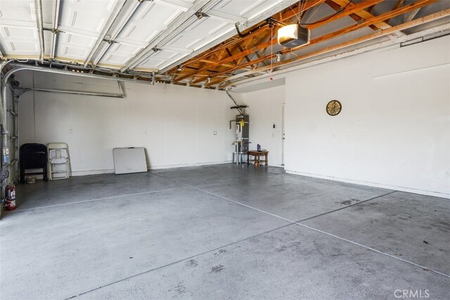 garage featuring a garage door opener and strapped water heater