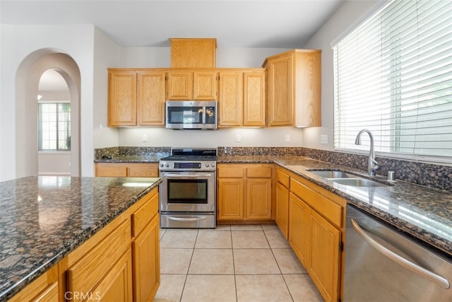 kitchen with plenty of natural light, sink, stainless steel appliances, and light tile patterned flooring