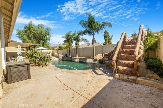 view of swimming pool featuring pool water feature and a patio area