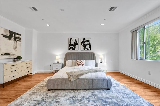 bedroom featuring ornamental molding and light wood-type flooring