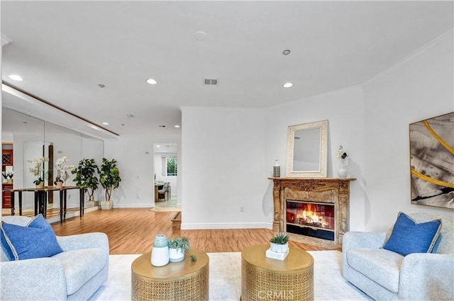 living room featuring a high end fireplace and light hardwood / wood-style floors